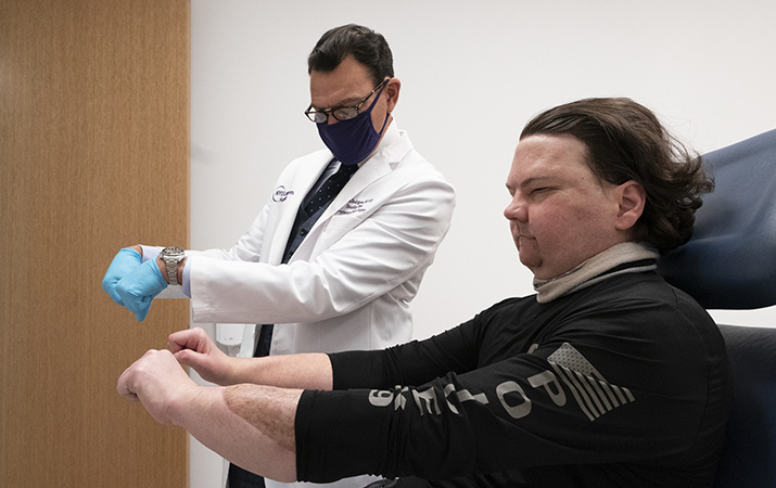 Dr. Eduardo Rodriguez has Joe DiMeo demonstrate the flexibility in his new hands, Monday, Jan. 25, 2021 at NYU Langone Health in New York. Rodriguez led a surgical team that amputated both of DiMeo???s hands, replacing them mid-forearm and connecting nerves, blood vessels and 21 tendons with hair-thin sutures. (AP Photo/Mark Lennihan)