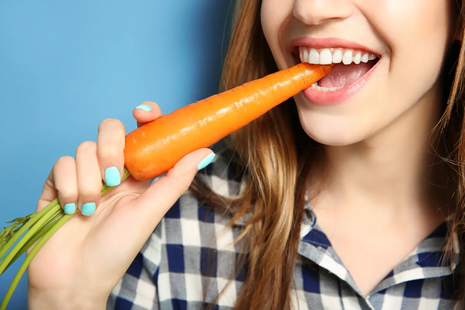 Девушка ест морковку 