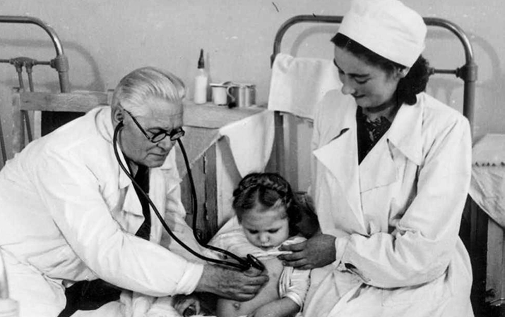 Василий Леонов осмотривает маленького пациента. Фото из архива А. В. Чантурия.