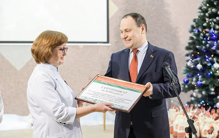 Премьер-министр Беларуси Роман  Головченко вручает  сертификат для закупки медицинского оборудования главному врачу  Надежде  Демидовой.